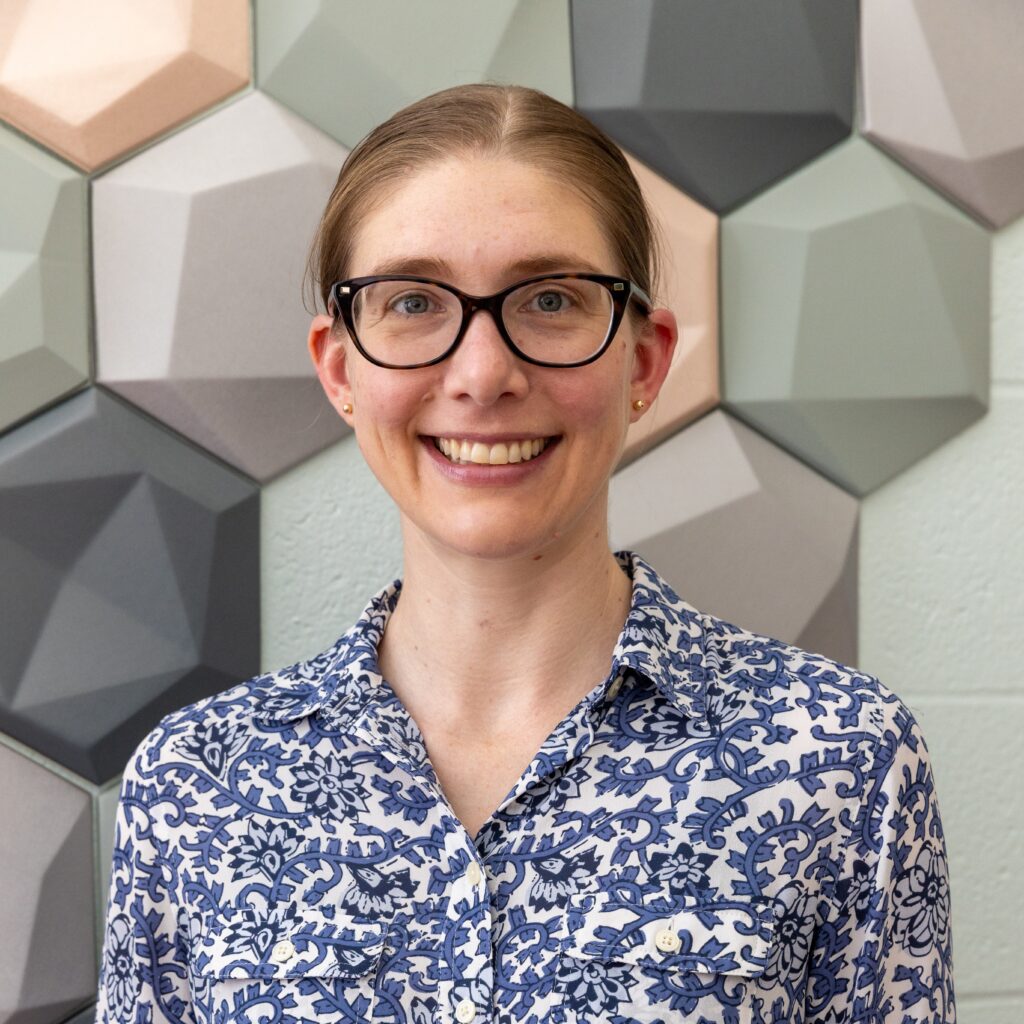 C. Rose Kennedy standing in front of hexagonal tiles