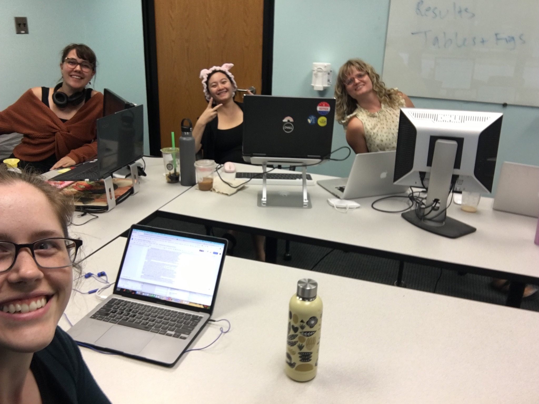 IDEA lab grad students Angela Santee, Gwyn DeLap & Katy Chang and Dr. Starr collaborate around a large conference table with computers
