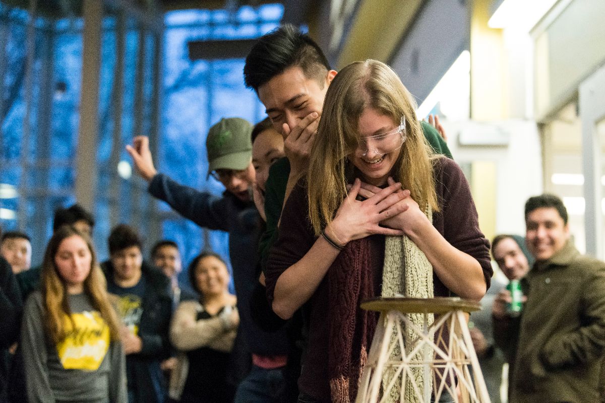 A woman embraces a man amidst a crowd, conveying a moment of connection and support at the University of Rochester.