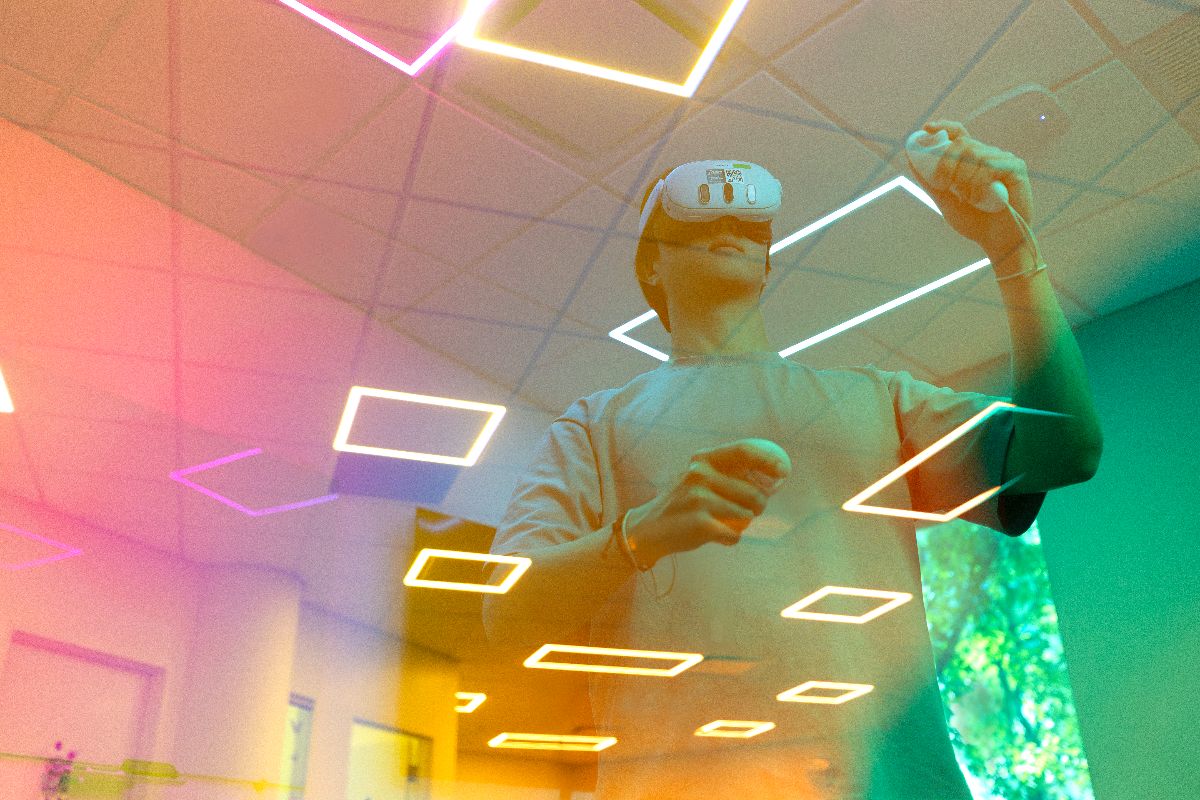 A man wearing a virtual reality headset in a room, engaged in an immersive digital experience.